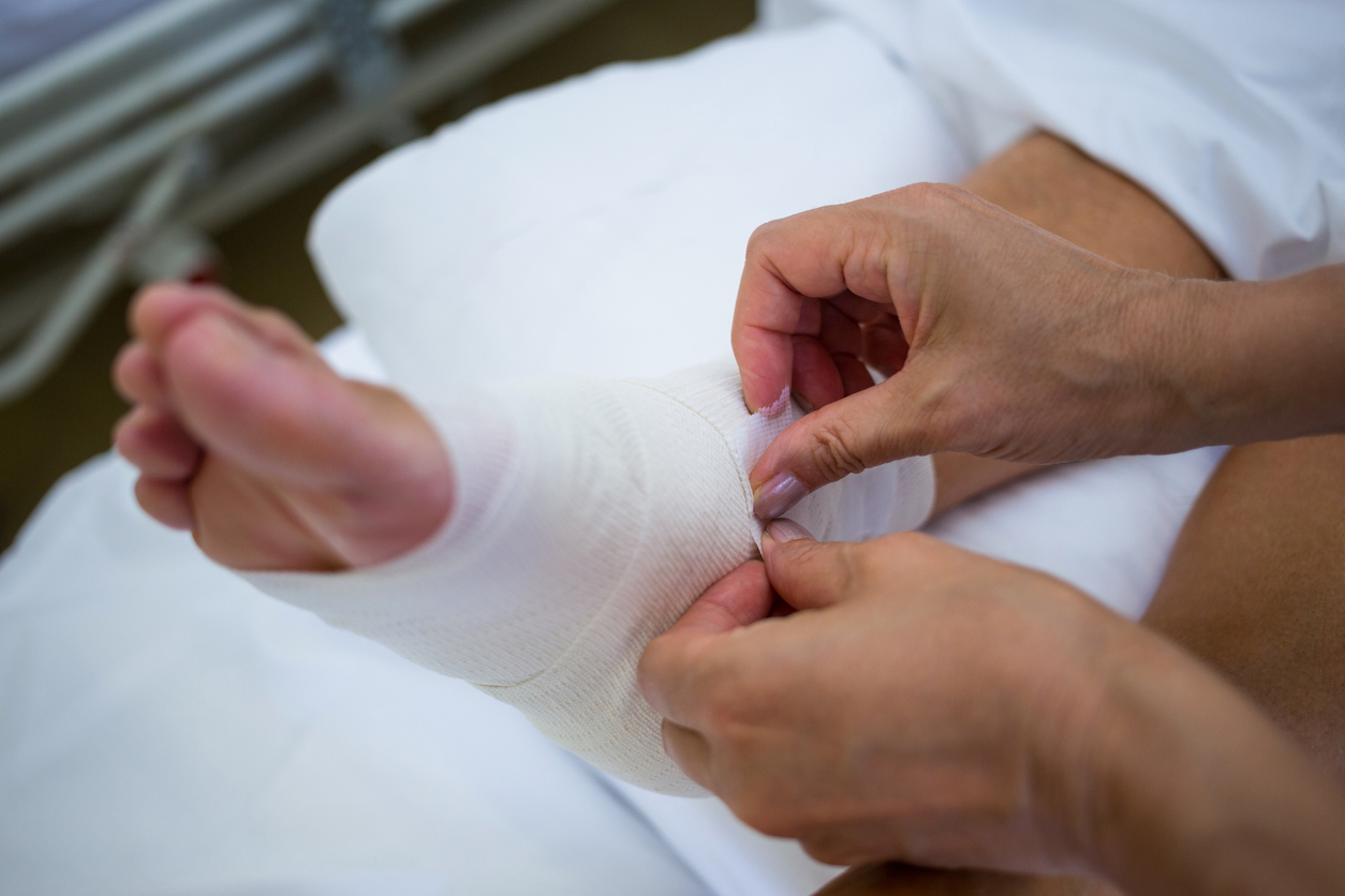 Doctor bandaging patients leg in hospital