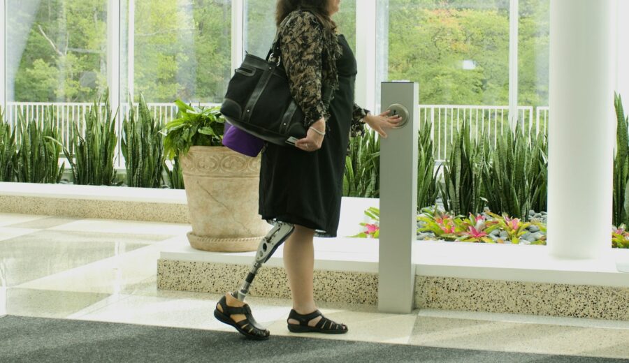 Woman confidently walking with a below-the-knee prosthetic, showcasing mobility and independence.