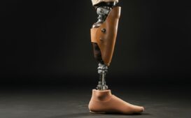 A prosthetic leg standing upright against a dark background, highlighting its sleek design and advanced technology.